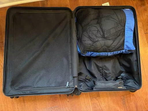 Quince responsible down puffer jacket packed in a suitcase